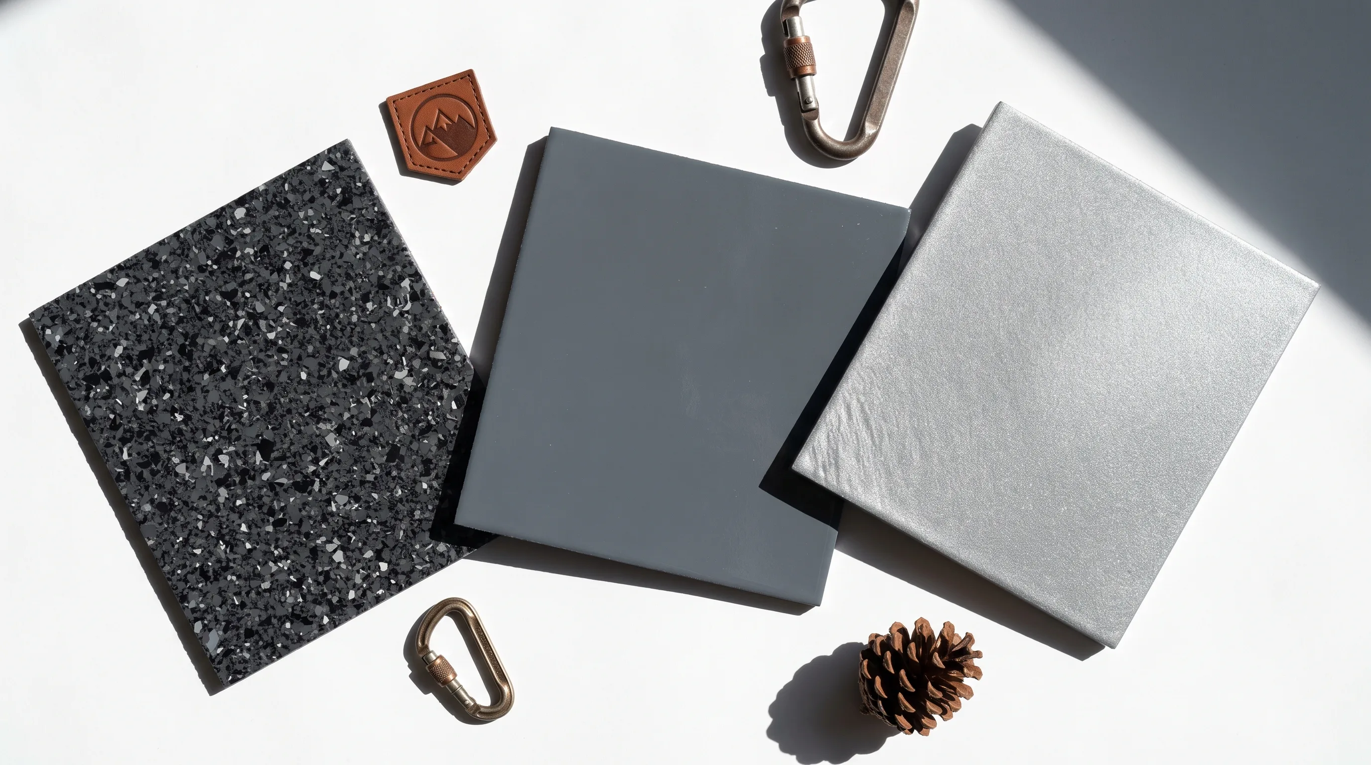 Overhead flat lay of epoxy garage floor color swatches — charcoal flake, slate gray, metallic silver